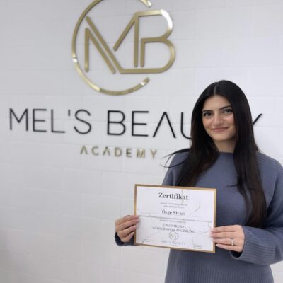 Absolventin einer Wimpernverlängerungs-Schulung hält ihr Zertifikat bei Mel’s Beauty & Academy in 5212 Hausen AG.
