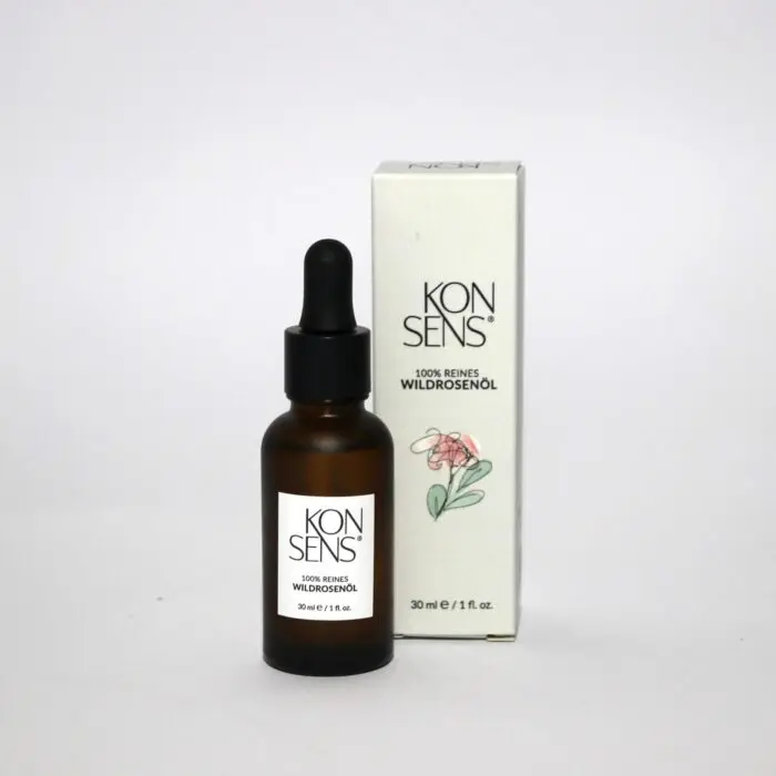“100% reines Wildrosenöl der Marke Konsens in einer hochwertigen Glasflasche mit Pipette, präsentiert neben der eleganten Verpackung. Erhältlich bei Mel’s Beauty & Academy.”